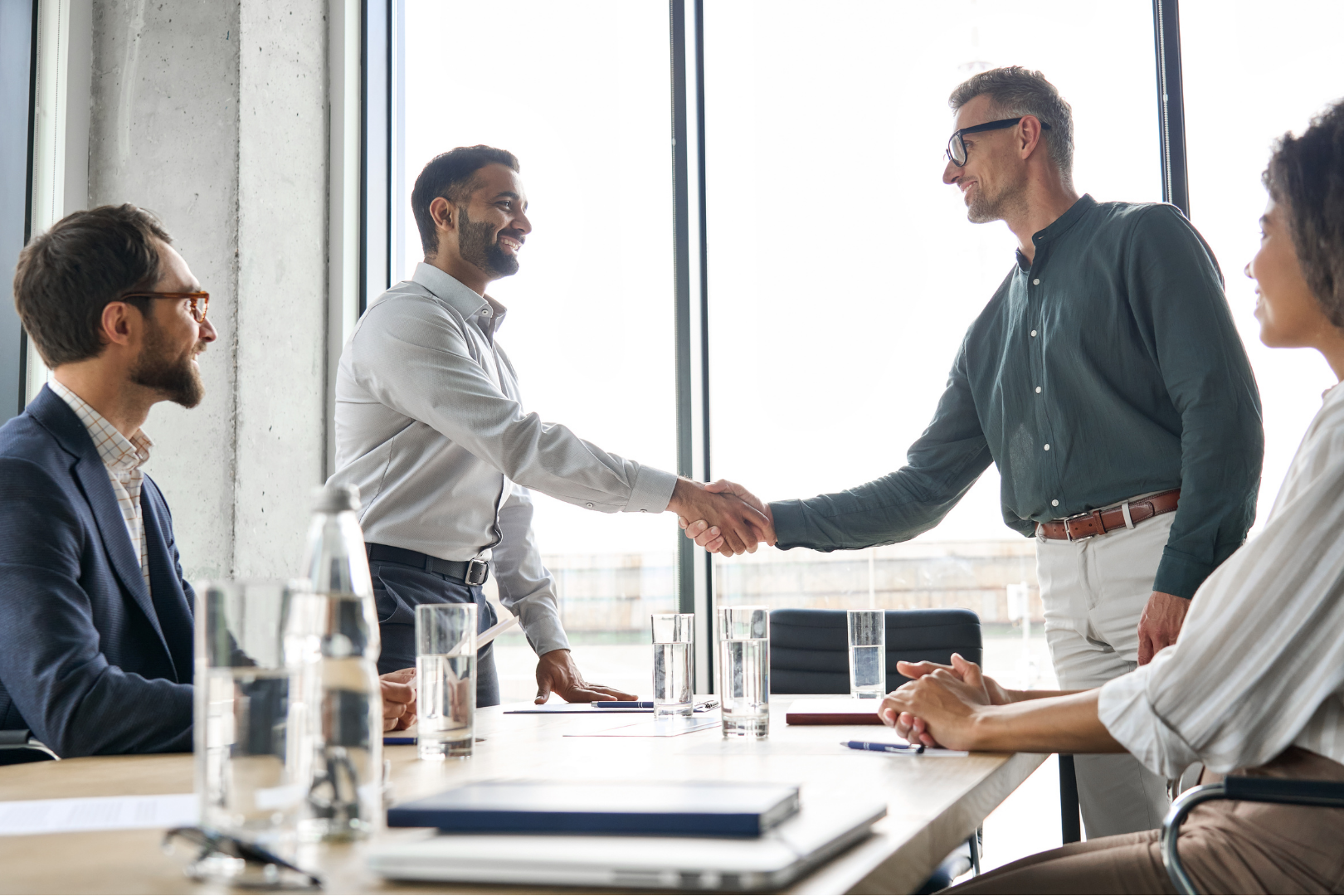 Business professionals shaking hands during a meeting representing a friendly and approachable team by Martin Shepherd Solicitors in North London, Hertfordshire, Potters Bar, and surrounding areas.