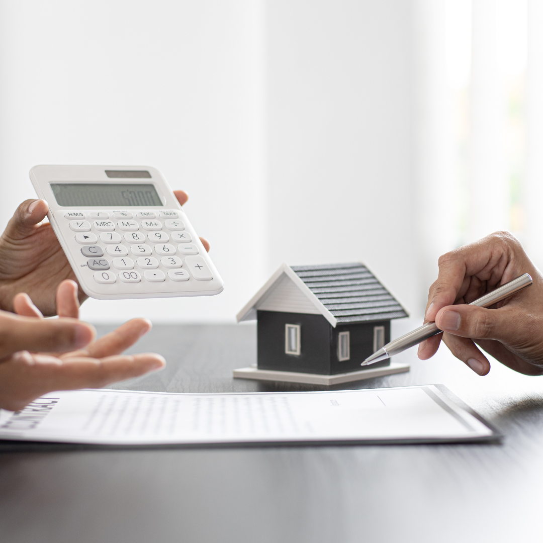 Hands holding a calculator and pointing to documents beside a model house representing calculating inheritance tax liabilities and planning future asset distribution with Martin Shepherd Solicitors in Potters Bar, Hertford and North Finchley, serving clients across North London and Hertfordshire.