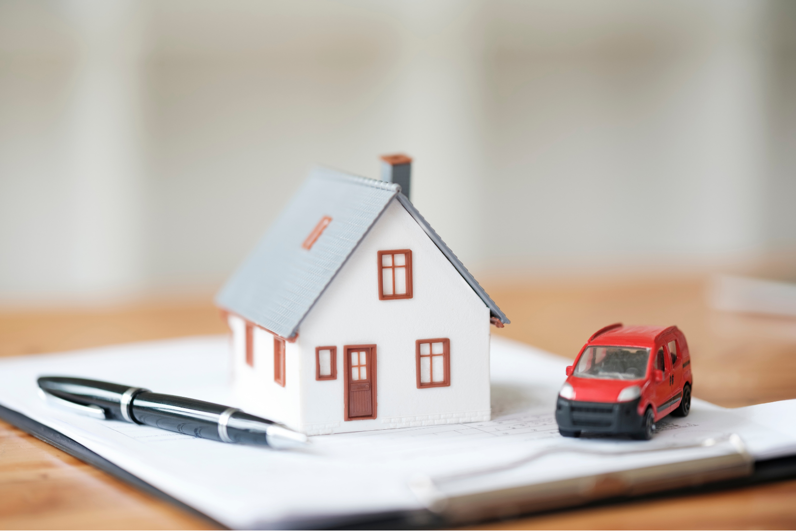Model house and miniature car on top of legal documents with a pen representing tailored guidance that balances financial planning with personal wishes for inheritance tax by Martin Shepherd Solicitors in Potters Bar, Hertford and North Finchley, helping clients in North London and Hertfordshire.