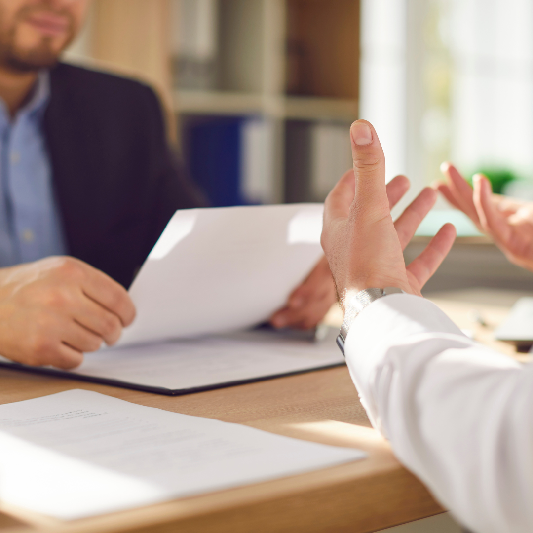 Two people in discussion during a meeting with legal documents on the table, representing creditor negotiation support by Martin Shepherd Solicitors in North London, Hertfordshire, Potters Bar, Hertford, and North Finchley.