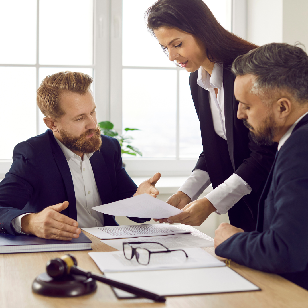 A solicitor and two clients reviewing a tenancy agreement in a bright office, representing landlord legal advice and tenancy services provided by Martin Shepherd Solicitors in Potters Bar, Hertford and North Finchley.